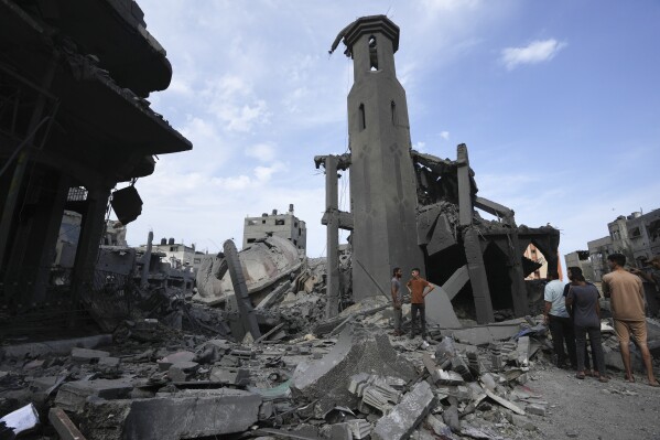 CORRECTS NAME OF THE MOSQUE - Palestinians inspect the rubble of the Sousi Mosque, destroyed after it was hit by an Israeli airstrike at Shati refugee camp in Gaza City, early Monday, Oct. 9, 2023. Israel's military battled to drive Hamas fighters out of southern towns and seal its borders Monday, as it pounded the Gaza Strip from the (AP Photo/Adel Hana)