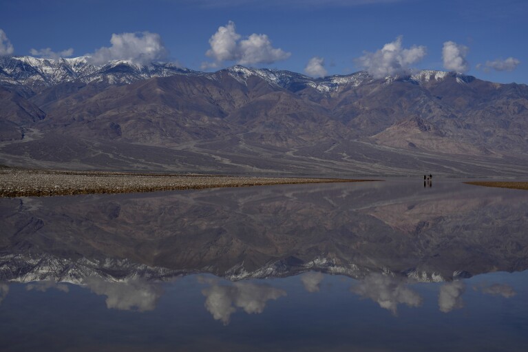 Snow capped mountains are reflected in water at Badwater Basin, Thursday, Feb. 22, 2024, in Death Valley National Park, Calif. The basin, normally a salt flat, has filled from rain over the past few months. (AP Photo/John Locher)