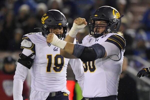 FILE - California nose tackle Brett Johnson, right, celebrates a sack with linebacker Cameron Goode during the first half of the team's NCAA college football game against UCLA on Saturday, Nov. 30, 2019, in Pasadena, Calif. When California opens the season at North Texas on Saturday, Golden Bears defensive lineman Brett Johnson may need a minute to soak in the moment. After missing two full seasons to deal with grueling injuries, Johnson is set to play a game for the first time in 1,001 days since a win over Oregon in an empty stadium on Dec. 5, 2020.(AP Photo/Mark J. Terrill, File)
