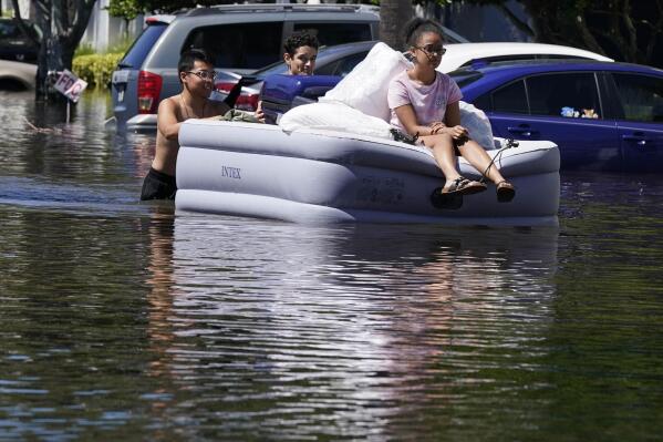 University of Central Florida students evacuate an apartment complex near the campus that was totally flooded by rain from Hurricane Ian, Friday, Sept. 30, 2022, in Orlando, Fla. AP Photo/John Raoux)