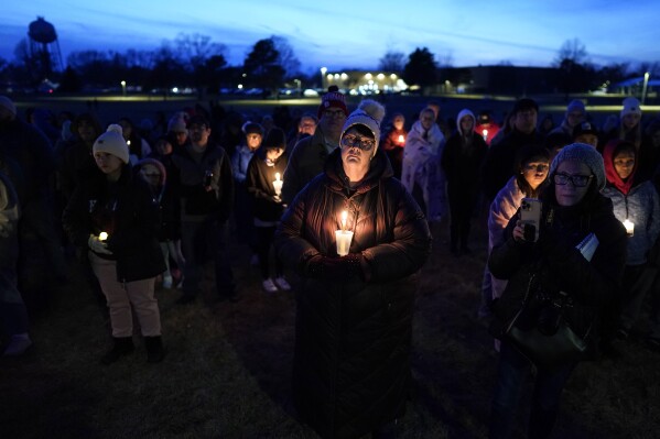 Local residents pray during a candlelight vigil after a shooting at Perry High School, Thursday, Jan. 4, 2024, in Perry, Iowa. (AP Photo/Charlie Neibergall)