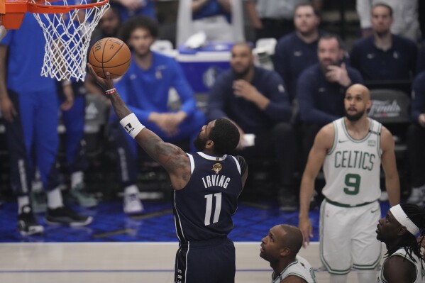 Dallas Mavericks guard Kyrie Irving (11) scores against the Boston Celtics during the first half in Game 4 of the NBA basketball finals, Friday, June 14, 2024, in Dallas. (AP Photo/Julio Cortez)