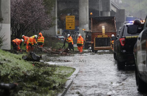 
              A Caltrans work crew removes debris near a flooded lane from under a freeway in San Francisco, Thursday, Feb. 14, 2019. The National Weather Service says the atmospheric river sagged southward from Northern California overnight and is pointed at the southwestern corner of the state early Thursday. (AP Photo/Jeff Chiu)
            