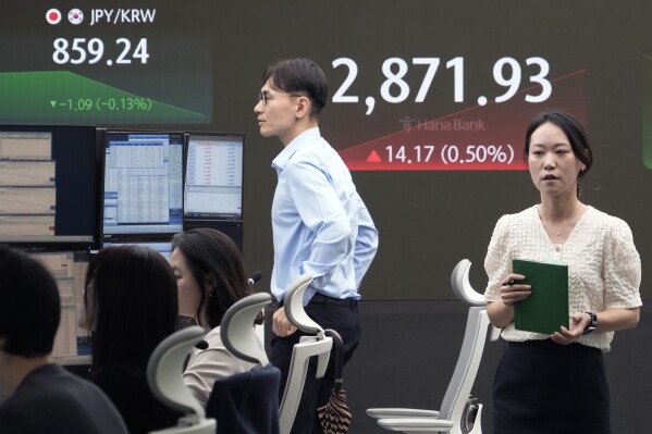 A currency trader passes by the screen showing the Korea Composite Stock Price Index (KOSPI) at the foreign exchange dealing room of the KEB Hana Bank headquarters in Seoul, South Korea, Tuesday, July 9, 2024. (ĢӰԺ Photo/Ahn Young-joon)