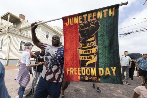 Robert Reid holds a flag during a Juneteenth celebration at the African Burying Ground Memorial Park Thursday, June 19, 2025, in Portsmouth, N.H. (AP Photo/Michael Dwyer)