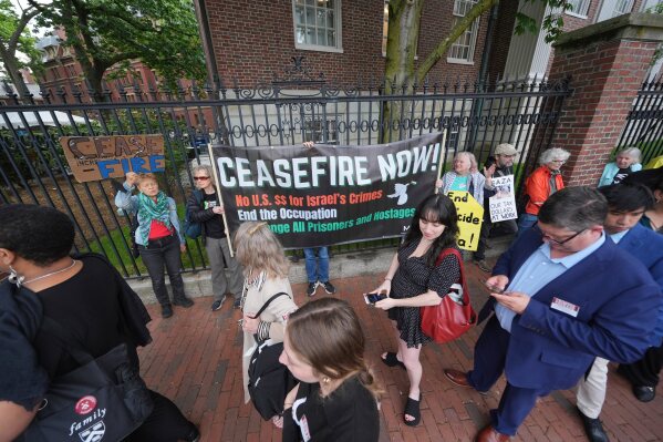 Guests for Harvard's commencement walk past protesters outside Harvard yard prior to commencement ceremonies, Thursday, May 29, 2025 in Cambridge, Mass. (AP Photo/Charles Krupa)