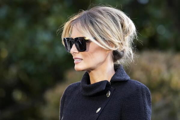 FILE - First Lady Melania Trump listens as President Donald Trump speaks with reporters as he walks to board Marine One on the South Lawn of the White House, Wednesday, Jan. 20, 2021, in Washington. The former first lady launched a venture this week selling non-fungible tokens that must be paid for with Solan cryptocurrency, currently valued around $180 each. Trump said she will release NFTs “in regular intervals” on her website, with a portion of the proceeds going to foster children. (AP Photo/Alex Brandon, File)