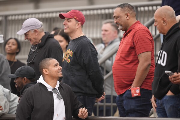 Chicago Bears general manager Ryan Poles, left, speaks with Carl Williams, father of Southern California quarterback Caleb Williams, second from right, at the school's NFL Pro Day, Wednesday, March 20, 2024, in Los Angeles. (AP Photo/Ryan Sun)