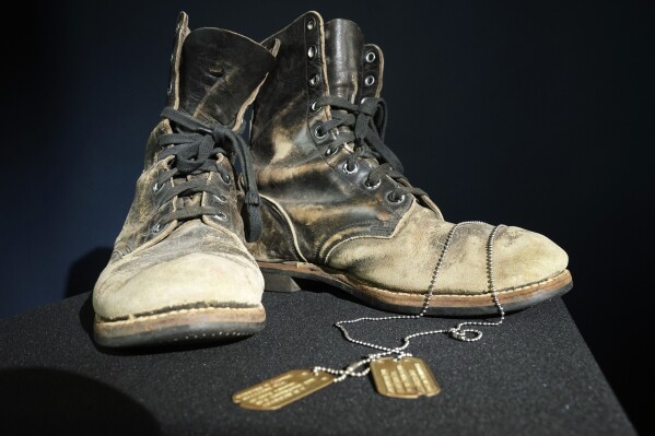 Combat boots and dog tags worn by Alan Alda as he portrayed the wisecracking surgeon Hawkeye on the beloved television series "M-A-S-H" are displayed at Heritage Auctions in Irving, Texas, Wednesday, July 5, 2023. The items are up auction on July 28. (AP Photo/LM Otero)