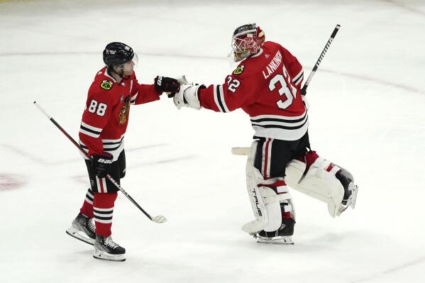 Chicago Blackhawks' Patrick Kane (88) celebrates his hat trick with goaltender Kevin Lankinen during the third period of an NHL hockey game against the New Jersey Devils on Friday, Feb. 25, 2022, in Chicago. The Blackhawks won 8-5. (AP Photo/Charles Rex Arbogast)