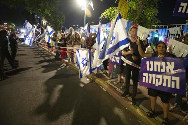Israeli left-wing protesters chant slogans and hold flags during a demonstration for the forming of a new government in the central Israeli city of Ramat Gan, Wednesday, June 2, 2021. Hebrew sign reads: "We are the hope". (AP Photo/Sebastian Scheiner)