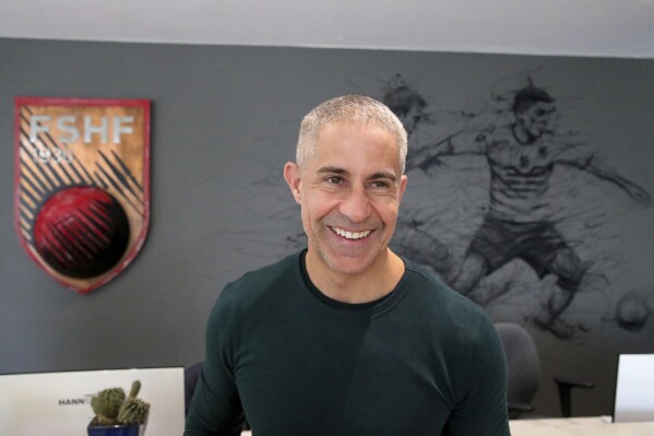 Albania's coach Sylvio Mendes De Campo of Brazil smiles during an interview with the Associated Press in Tirana, Albania, Wednesday, Nov. 22, 2022. Taking it into the Euro 2024 finals was a dream come true for Albania's Latin coaches. Their next challenge is "a good play" at the finals in Germany and turning it into strong team. (AP Photo/Armando Babani)