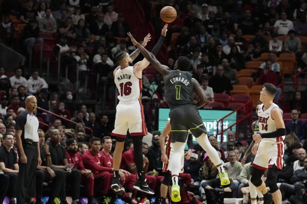 Miami Heat forward Caleb Martin (16) shoots as Minnesota Timberwolves guard Anthony Edwards (1) defends during the first half of an NBA basketball game, Monday, Dec. 26, 2022, in Miami. (AP Photo/Lynne Sladky)