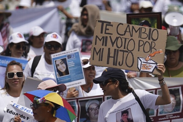 FILE - A woman holds up a sign with a message written in Spanish. "I vote for my son." Marchers speak of this year's presidential election during the annual National Search for Their Mothers march in Mexico City, May 10, 2024. Marchers say the government has shown no interest in investigating the disappearances of Mexico's more than 100,000 missing people. (AP Photo/Marco Ugarte, File)