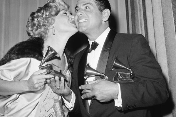 FILE - Ross Bagdasrian gets a kiss from singer Helen Greco as she handed him the third of three Grammys he won on May 4, 1959 in Los Angeles. He won Grammys for Best Recording for Children, Best Comedy Performance, and Best Non-Classical Engineered Song. (AP Photo/Don Brinn, File)