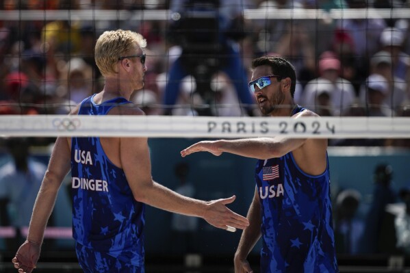 US' Chase Budinger and Miles Evans react during the men's round of 16 beach volleyball match between USA and Norway at Eiffel Tower Stadium at the 2024 Summer Olympics, Monday, Aug. 5, 2024, in Paris, France. (AP Photo/Louise Delmotte)