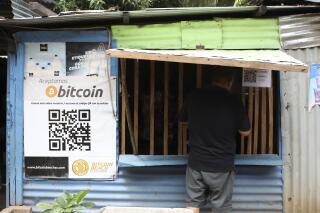 A worker at Hope House, an organization that sponsors the use of cryptocurrencies in El Zonte beach, makes a purchase at a small store that accepts Bitcoin, in Tamanique, El Salvador, Wednesday, June 9, 2021. El Salvador's Legislative Assembly has approved legislation making the cryptocurrency Bitcoin legal tender in the country, the first nation to do so, just days after President Nayib Bukele made the proposal at a Bitcoin conference. (AP Photo/Salvador Melendez)