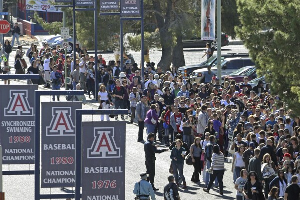 FILE - People line up to get into a memorial service at McKale Memorial Center on the University of Arizona campus, Jan. 12, 2011, in Tucson, Ariz. On Wednesday, Dec. 13, 2023, the University of Arizona unveiled an extensive financial recovery plan to address its $240 million budget shortfall. (AP Photo/Chris Carlson, File)