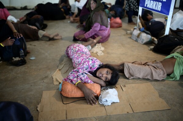 A Rohingya girl lies on the floor as she and her group take shelter in the basement of a building in Banda Aceh, Aceh province, Indonesia, Tuesday, Dec. 12, 2023. Hundreds of Rohingya Muslims from two groups carried out by two boats arrived on beaches in Indonesia's Aceh province on Sunday. These groups have been denied to the Aceh residents who are hesitant to let them sheltered around their houses. (AP Photo/Reza Saifullah)