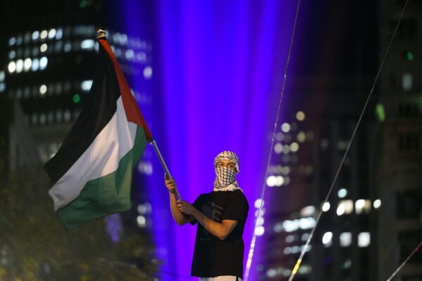 FILE - A demonstrator waves a Palestinian flag during a protest in opposition to the Israel-Hamas war in conjunction with the APEC Summit taking place on Nov. 14, 2023, in San Francisco. (AP Photo/Godofredo A. V谩squez, File)