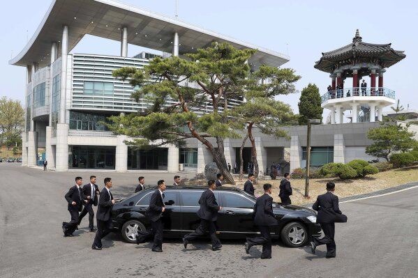 
              CORRECTS SPELLING OF MOON JAE-IN - North Korean security persons run by a car carrying North Korean leader Kim Jong Un return to the North side for a lunch break after a morning session of a summit meeting with South Korean President Moon Jae-in at the border village of Panmunjom in Demilitarized Zone Friday, April 27, 2018. Their discussions will be expected to focus on whether the North can be persuaded to give up its nuclear bombs. (Korea Summit Press Pool via AP)
            