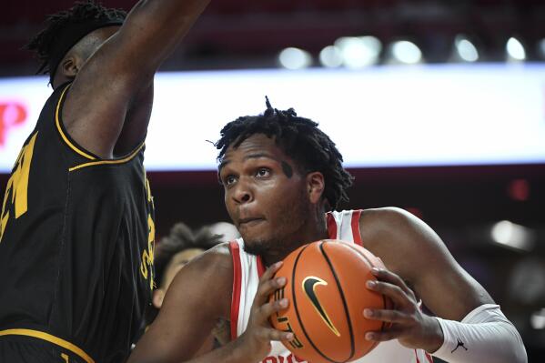 Houston center Josh Carlton attempts to pass the ball around Wichita State forward Morris Udeze during the first half of an NCAA college basketball game Saturday, Jan. 8, 2022, in Houston. (AP Photo/Justin Rex)
