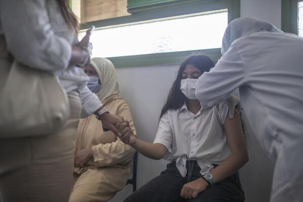 School students and their parents wait to receive their COVID-19 vaccines  as Morocco launches a campaign to vaccinate 12-17 year olds before the  start of the school year, in Rabat, Morocco, Tuesday