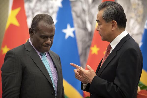 FILE - Solomon Islands Foreign Minister Jeremiah Manele, left, and Chinese Foreign Minister Wang Yi talk during a ceremony to mark the establishment of diplomatic relations between the Solomon Islands and China at the Diaoyutai State Guesthouse in Beijing on Sept. 21, 2019. Wang is visiting the South Pacific with a 20-person delegation this week in a display of Beijing's growing military and diplomatic presence in the region. (AP Photo/Mark Schiefelbein, Pool, File)