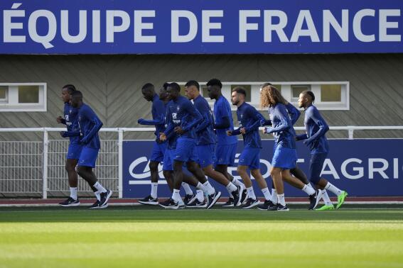 French soccer players warm up during a training session of the French national soccer team at Clairefontaine training center, south of Paris, France, Monday, Sept. 19, 2022. (AP Photo/Francois Mori)