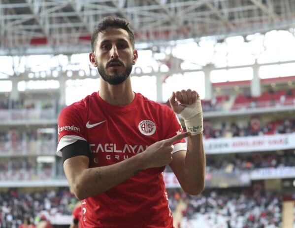 FILE - Antalyaspor's Sagiv Jehezkel points a message in his bandage that reads: "100 days. 7.10" as he celebrates after scoring his side's first goal during a Turkish Super Lig soccer match between Antalyaspor and Trabzonspor in Antalya, southern Turkey, Sunday, Jan. 14, 2024. Turkish top-flight soccer club Basaksehir announced Thursday that it was parting ways with its Israeli player Eden Karzev. Basaksehir's decision came days after another Israeli player, Sagiv Jehezkel, was briefly detained in Turkey for allegedly inciting hatred after he expressed solidarity with the hostages after scoring an equalizer during a top-division game. (Adem Akalan/DHA via AP, File)