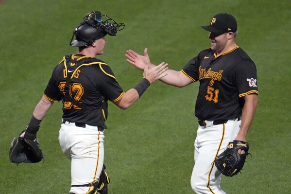 Pittsburgh Pirates relief pitcher David Bednar (51) celebrates with catcher Henry Davis after the team's win over the Los Angeles Dodgers in a baseball game in Pittsburgh, Tuesday, June 4, 2024. (AP Photo/Gene J. Puskar)