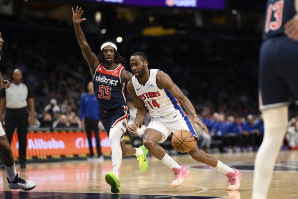 Detroit Pistons guard Alec Burks (14) drives to the basket against Washington Wizards guard Delon Wright (55) during the first half of an NBA basketball game, Monday, Jan. 15, 2024, in Washington. (AP Photo/Nick Wass)
