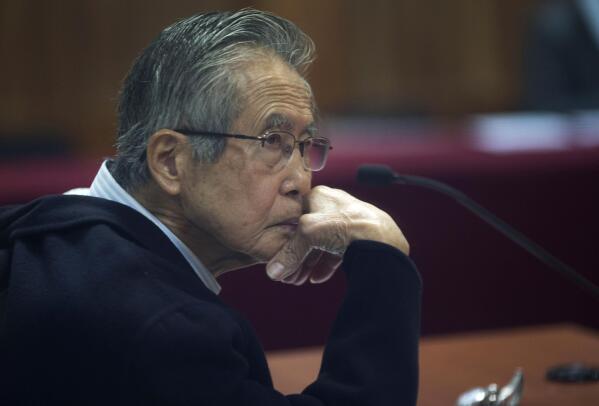 FILE - Peru's jailed, former President Alberto Fujimori, photographed through a glass window, attends his trial at a police base on the outskirts of Lima, Peru, June 28, 2016. A Peruvian judge on Thursday, March 24, 2022, banned Fujimori from leaving the country for 18 months upon his released from prison where he is serving a 25-year sentence for murder. (AP Photo/Martin Mejia, File)