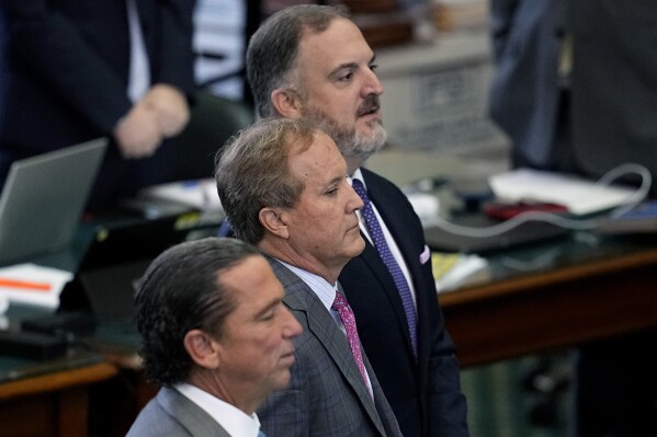 Suspended Texas state Attorney General Ken Paxton, center, stands with his attorneys Tony Buzbee, front, and Mitch Little, rear as his impeachment trial continues in the Senate Chamber at the Texas Capitol, Friday, Sept. 15, 2023, in Austin, Texas. (AP Photo/Eric Gay)