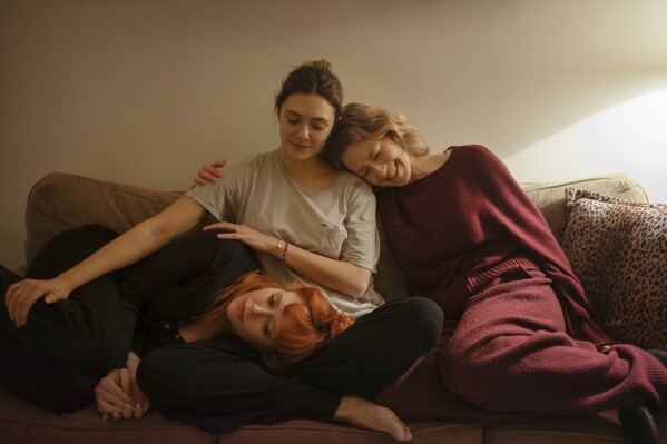 This image released by Netflix shows Natasha Lyonne, from left, Elizabeth Olsen, and Carrie Coon in a scene from "His Three Daughters." (Netflix via AP)