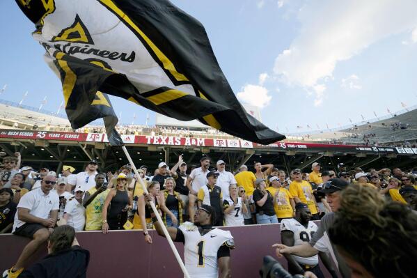 Appalachian State defensive back Kaleb Dawson (1) waves his school's flag inside of Kyle Field after upsetting Texas A&M 17-14 in an NCAA college football game Saturday, Sept. 10, 2022, in College Station, Texas. (AP Photo/Sam Craft)