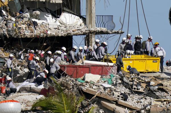 FILE - In this June 28, 2021, file photo, workers search the rubble at the Champlain Towers South Condo in Surfside, Fla. Search and rescue teams from Miami-Dade have been described as among the best and most experienced in the world.  (AP Photo/Lynne Sladky, File)