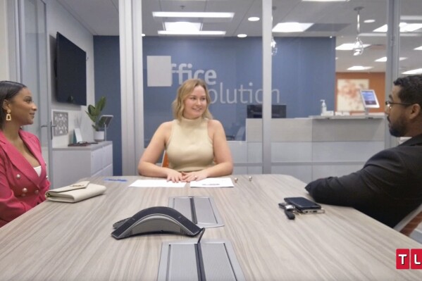 This image released by TLC shows Chantel Everett, left, and Pedro Jimeno, right, with a realtor in a scene from the reality series "The Family Chantel." (TLC via AP)