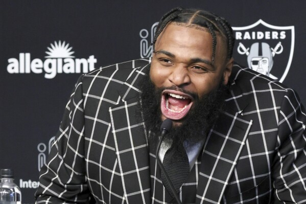 Las Vegas Raiders defensive tackle Christian Wilkins yells "Raiders!" at the start of an NFL football news conference, Thursday, March 14, 2024, in Henderson, Nev. (Steve Marcus/Las Vegas Sun via AP)