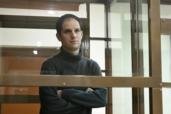 FILE - Wall Street Journal reporter Evan Gershkovich stands in a glass cage in a courtroom at the Moscow City Court, in Moscow, Russia, on Dec. 14, 2023. An estimated 320 journalists around the world were imprisoned because of their work toward the end of 2023. That's from the Committee to Protect Journalists, which on Thursday, Jan. 18, 2024 issued its annual census as of Dec. 1, 2023. (AP Photo/Dmitry Serebryakov, file)