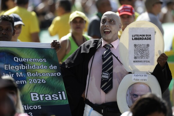 A supporter of former President Jair Bolsonaro, dressed as Supreme Court Justice Alexandre de Moraes, takes part in a rally on Copacabana Beach in support of a proposed bill to grant amnesty to those arrested for storming government buildings in an alleged coup attempt in 2023, in Rio de Janeiro, Sunday, March 16, 2025. (AP Photo/Bruna Prado)