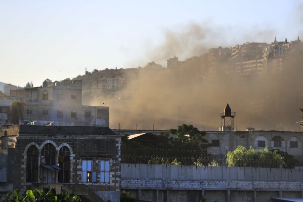 Smoke rises during clashes between members of the Palestinian Fatah group and Islamist militants in the Palestinian refugee camp of Ein el-Hilweh near the southern port city of Sidon, Friday, Sept. 8, 2023. Clashes resumed in Lebanon's largest Palestinian camp overnight, with heavy gunfire and shelling wounding several people and prompting residents of the camp and the surrounding area to flee Friday. (AP Photo/Mohammed Zaatari)