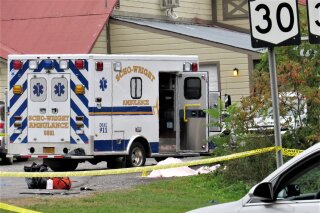 FILE - In this Saturday, Oct. 6, 2018 file photo, a body is draped under a blanket at the scene of a fatal crash in Schoharie, N.Y. A criminal case is preventing federal safety officials from conducting a full examination of the limousine involved in a crash that killed 20 people nearly two weeks ago in upstate New York.(Tom Heffernan Sr. via AP, File)