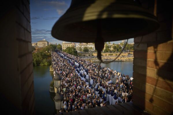 Penitents of the Estrella brotherhood walk in procession across the so-called Triana bridge during Holy Week in Seville, Spain, Sunday, April 13, 2025. Hundreds of processions take place throughout Spain during the Easter Holy Week. (AP Photo/Emilio Morenatti)