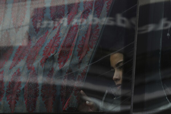 A migrant looks out the window on a bus on her way north to Nicaragua and hopefully to the Mexico-United States border, in Paso Canoas, Costa Rica, Monday, Oct. 16, 2023. Panama and Costa Rica launched a plan to quickly bus thousands of migrants through Panama to the Costa Rican border, as the countries continue to grapple with the increasing number of migrants. (AP Photo/Carlos Gonzalez)