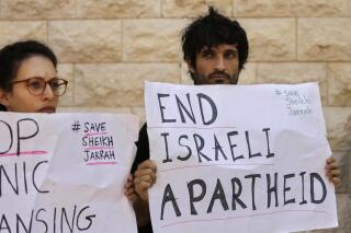 Protesters hold signs during a hearing on the possible evictions of Palestinian from the Sheikh Jarrah neighborhood of Jerusalem, outside the Supreme Court in Jerusalem, Monday, Aug. 2, 2021. (AP Photo/Maya Alleruzzo)