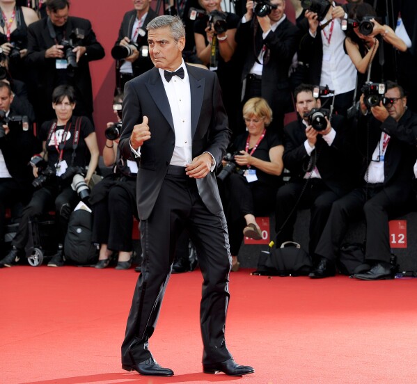 FILE - US actor George Clooney arrives on the red carpet for the premiere of his movie "The Ides of March," opening the 68th edition of the Venice Film Festival in Venice, Italy on Aug. 31, 2011. (AP Photo/Jonathan Short, File)