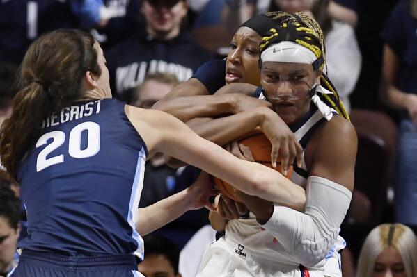 UConn's Aaliyah Edwards, right, fights for possession of the ball against Villanova's Maddy Siegrist, left, and Villanova's Christina Dalce, back center, during the first half of an NCAA college basketball game in the finals of the Big East Conference tournament, Monday, March 6, 2023, in Uncasville, Conn. (AP Photo/Jessica Hill)