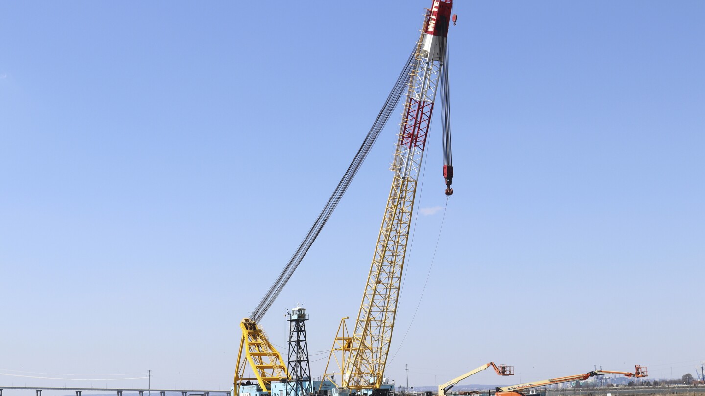 A floating crane arrived at the wreckage of the collapsed Francis Scott Key Bridge in the Patapsco River, as teams of engineers are working on the dau