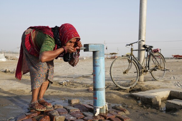 A woman drinks water from a public tap near the River Ganges on a hot summer day in Prayagraj, India, Thursday, May 2, 2024. (Ǻ Photo/Rajesh Kumar Singh)